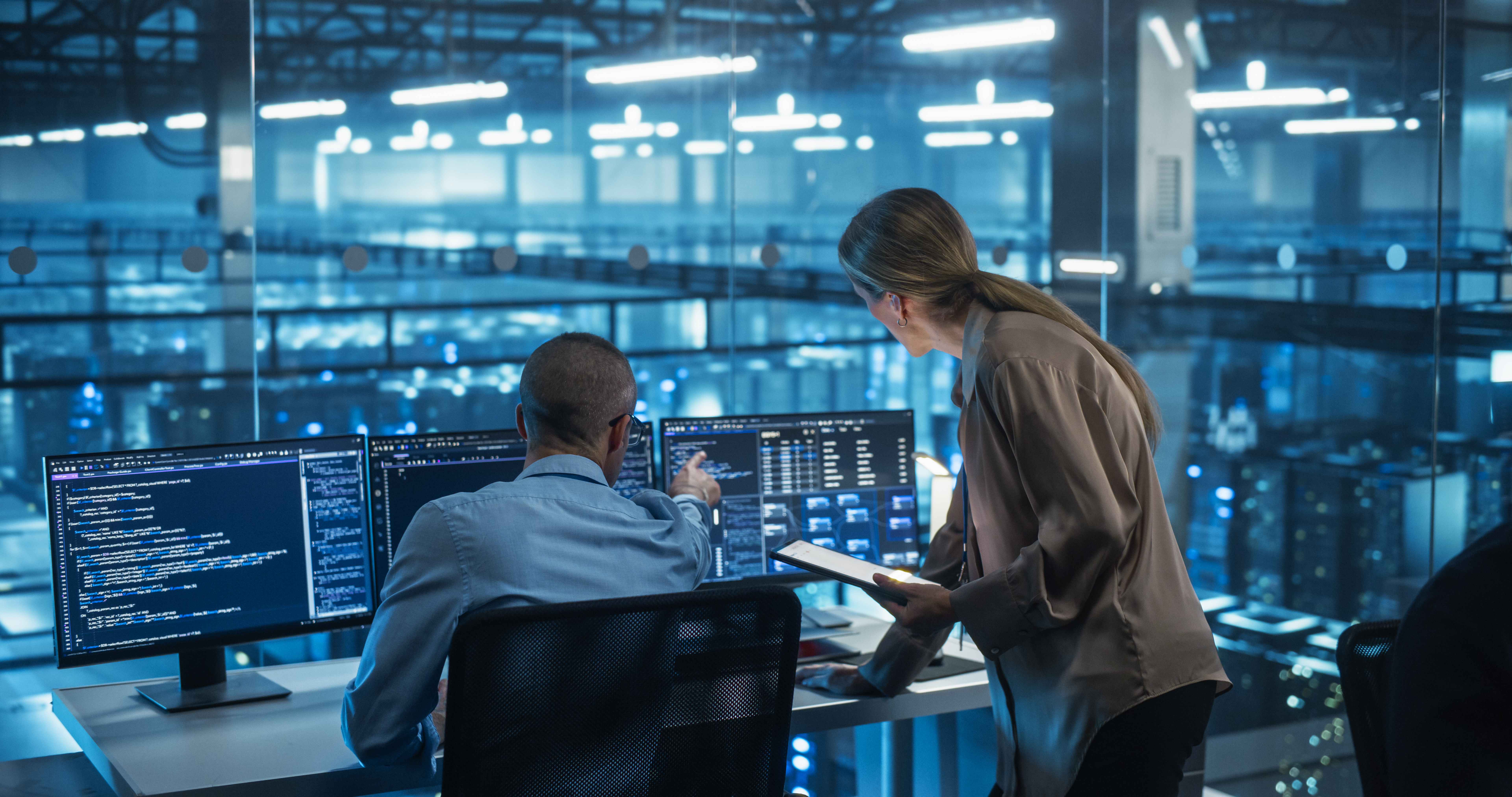 An enterprise operations and compliance team reviewing analytics in a modern data-center control room